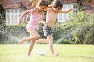 girls playing in sprinklers