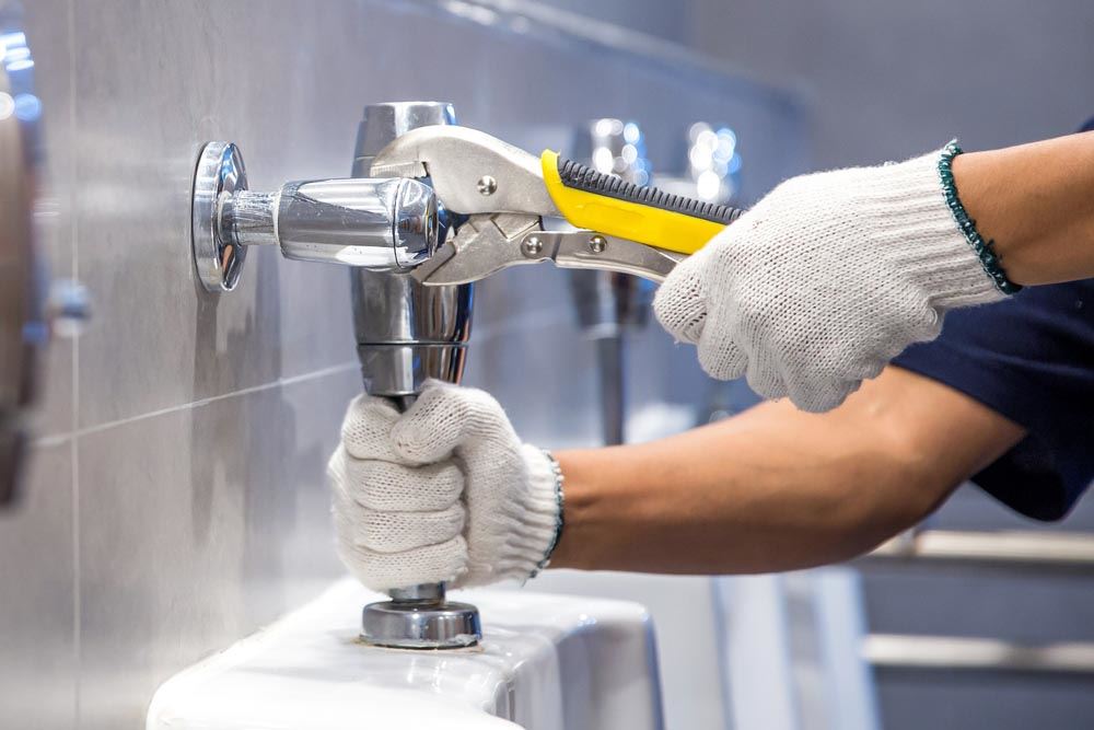 plumber using a wrench to fix or repair leaking water pipes